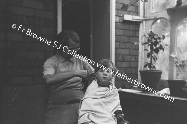 MRS R J MARTIN (ETTE) AND GRANDSON (JOHNNY)  CUTTING HIS HAIR  AT LOWOOD